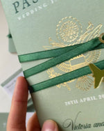Reisepass-Hochzeitseinladung salbeigrün mit Goldfolie und graviertem Flugzeuganhänger