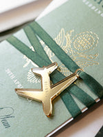 Reisepass-Hochzeitseinladung salbeigrün mit Goldfolie und graviertem Flugzeuganhänger